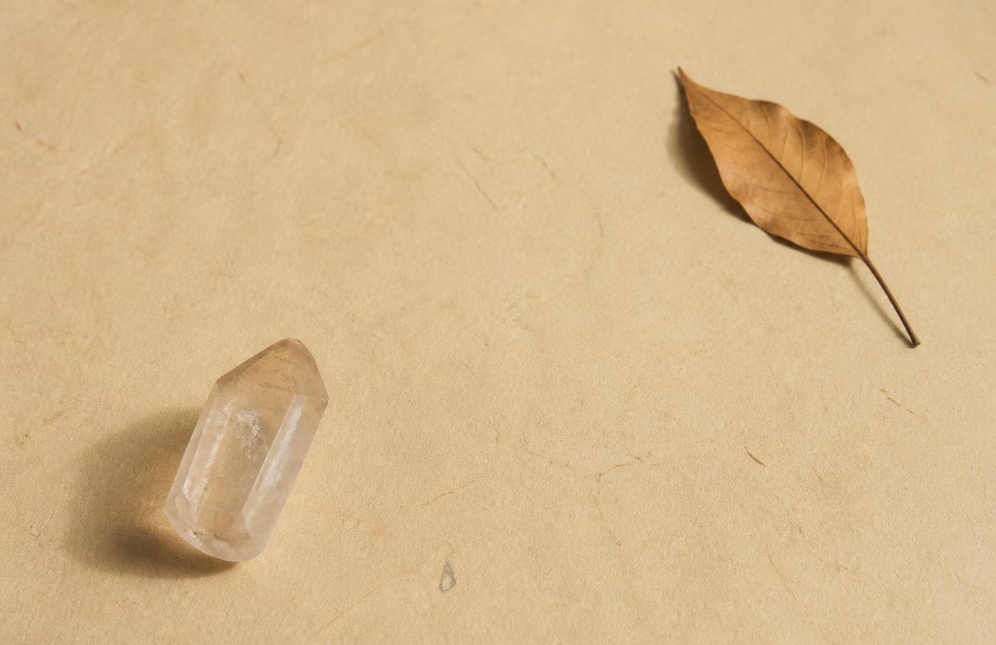 Cristal natural sobre papel artesanal com uma folha seca
